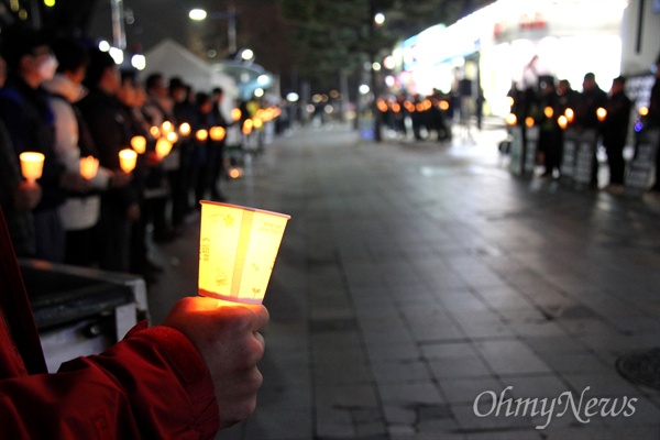 12월 20일 저녁 창원 정우상가 앞에서 열린 '태안화력 비정규직 24살 고 김용균님 추모문화제"에서 참가자들이 촛불을 들고 서 있다.