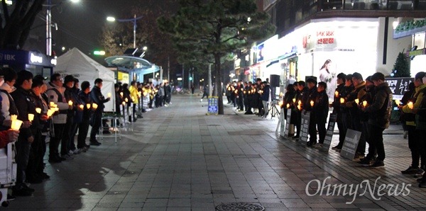 12월 20일 저녁 창원 정우상가 앞에서 열린 '태안화력 비정규직 24살 고 김용균님 추모문화제"에서 참가자들이 촛불을 들고 서 있다.