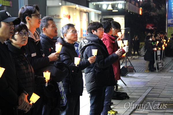 12월 20일 저녁 창원 정우상가 앞에서 열린 '태안화력 비정규직 24살 고 김용균님 추모문화제"에서 참가자들이 촛불을 들고 서 있다.