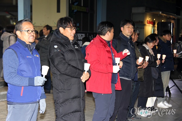 12월 20일 저녁 창원 정우상가 앞에서 열린 '태안화력 비정규직 24살 고 김용균님 추모문화제"에서 류조환 민주노총 경남본부장(왼쪽) 등 참가자들이 촛불을 들고 서 있다.
