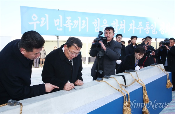 12월 26일 북측 개성 판문역에서 남북 철도·도로 연결 및 현대화 착공식의 세부일정으로 김현미 국토교통부 장관 과 김윤혁 철도성 부상이 침목서명식을 하고 있다.