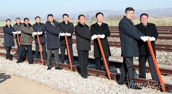 2018년 12월 26일 오전 개성 판문역에서 진행된 '동·서해선 남북 철도·도로 연결 및 현대화 착공식'에서 남북 관계자들이 궤도 체결식을 갖고 있다.