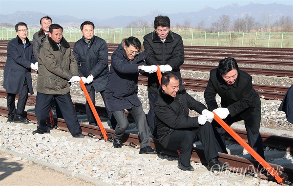 2018년 12월 26일 오전 개성 판문역에서 진행된 '동·서해선 남북 철도·도로 연결 및 현대화 착공식'에서 남북 관계자들이 궤도 체결식을 하고 있는 모습. 