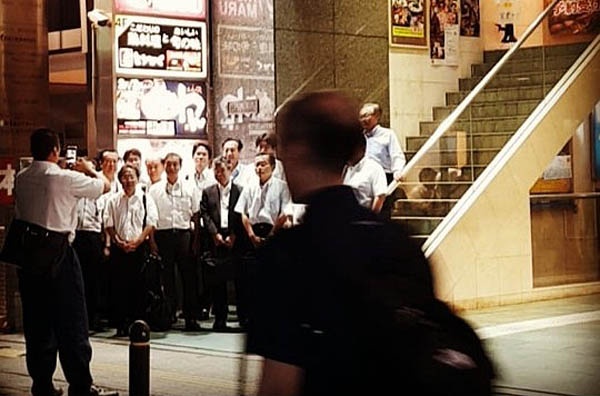 일본 도쿄 미나토구의 한 번화가에서 직장인들이 회식을 마친 뒤 기념촬영하고 있다.