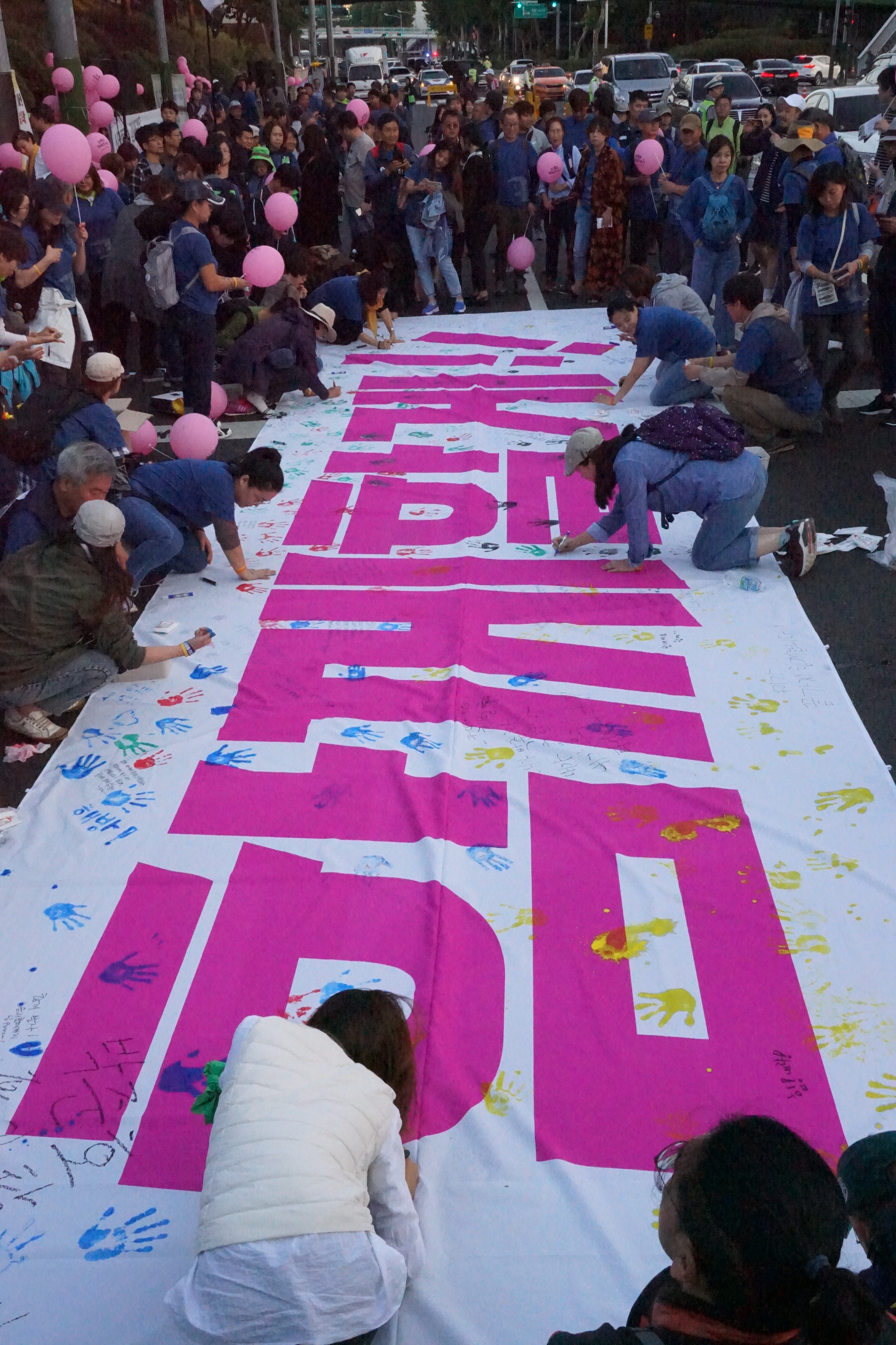 10월 3일 수요일 개천절 '파인텍 일일조합원의 날'이 열렸다. 참가자들이 마지막에 ‘함께할게!!’란 대형 현수막에 글을 쓰고 있다.