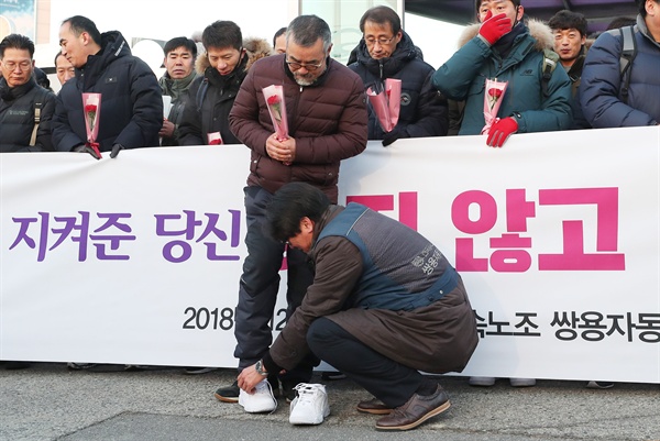 31일 오전 경기도 평택시 쌍용자동차 평택공장 앞에서 열린 쌍용차 해고 노동자 복직 첫 출근 기념행사에서 김득중 금속노조 쌍용차지부장(오른쪽)이 김정우 전 지부장에게 새 신발을 선물하고 있다.