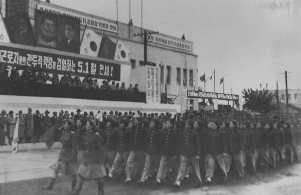  5.1절 경축군중대회에서 혁명자 유가족학원 학생들이 행진하고 있다. 그때 단상에 태극기가 게양된 게 이채롭다. 북한에서는 인공기를 1947년에 만든 뒤, 공식적으로 쓰기 시작한 시기는 1948년 7월 10일이라고 한다(나무 위키). 이 날 다른 장면에서는 인공기가 게양되어 있는것으로 보아 이때는 두 가지 다 쓴 시기로 추측된다.