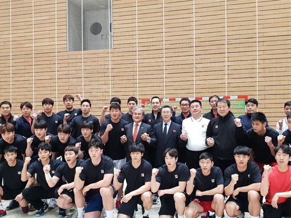 정범구 남측 대사와 박남영 북측 대사가 남자 핸드볼 남북 단일팀과 함께 기념 촬영하는 장면.