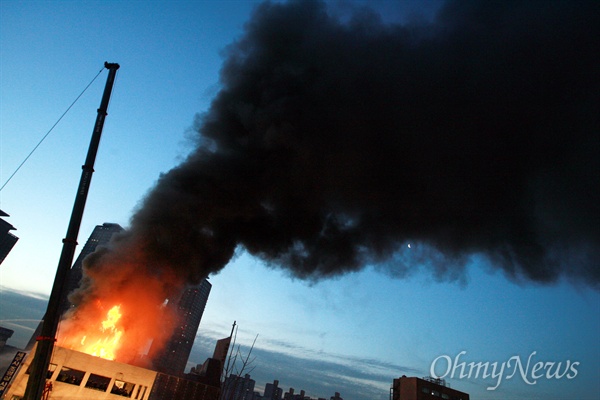 2009년 1월 20일 새벽 서울 신용산역 부근 5층 건물 옥상에 설치된 철거민 농성용 가건물이 경찰특공대 진입 과정에서 불길에 휩싸여 시커먼 연기를 내며 무너지고 있다.