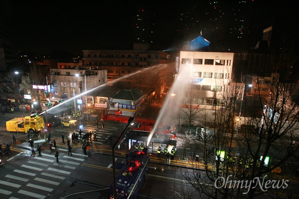 20일 새벽 서울 용산구 신용산역 부근 재개발 지역내 5층 건물에서 농성중인 철거민들을 향해 경찰이 살수차로 물을 뿌리고 있다.