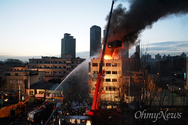 20일 새벽 서울 용산구 한강로 2가 재개발지역에서 철거민들이 5층 건물 옥상에 가건물을 설치하고 농성을 벌이던 모습. 누가 과연 그들을 그 높은 곳으로 밀어올렸는가. 