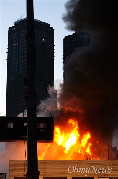 지난 2009년 1월 20일 새벽 서울 용산구 한강로 2가 재개발지역에서 농성중인 철거민들을 진압하기 위해 경찰특공대가 컨테이너에 실려 고공투입된 가운데, 철거민들이 농성중이던 가건물이 불길에 휩싸인 채 무너지고 있다.
