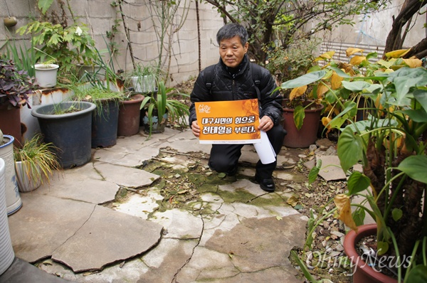 전태일 열사의 동생 전태삼씨가 전태일 열사가 살았던 대구시 중구 남산동 집에서 손피켓을 들고 있는 모습.
