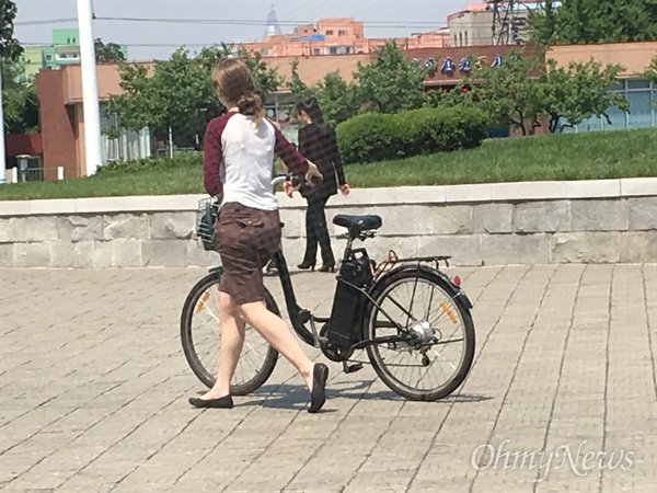  평양 길거리에서 본 외국인 거주자. 자전거를 끌고 가고 있다. 