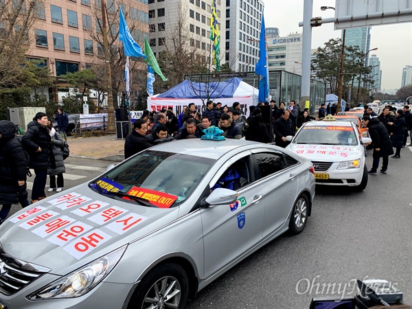  '불법 카풀영업 척결을 위한 비상대책위원회'에 참여한 4개 택시단체 대표들이 10일 오후 서울 여의도 국회 앞 농성장에서 고 임정남씨의 죽음을 애도하는 성명서를 발표한 뒤 "카카오 택시 앱 불매운동"이라고 써붙인 택시에 타고 청와대로 이동하고 있다.