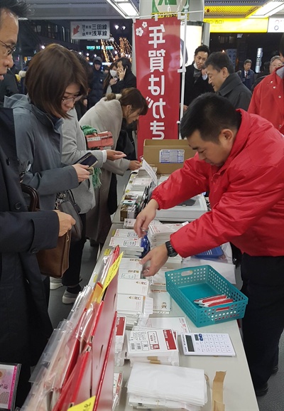 도쿄 미나토구 다마치역 구내에 설치된 연하장 판매대. 빨간 유니폼을 입은 우체국 직원들이 나와 연하장 구매를 독려한다.