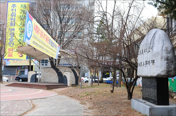 매년 을미의병과 유성장터 독립만세운동 재연행사를 진행하고 있는 장터공원. ‘을미의병의 효시 유성의병사적비’ 주변에도 ‘재개발사업조합설립추진위원회’에서 걸어 놓은 현수막이 걸려 있다.