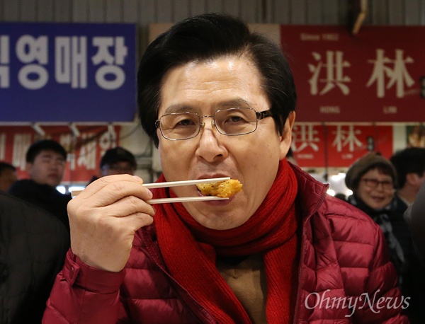 자유한국당 당대표 경선에 출마한 황교안 전 국무총리가 1월 31일 오후 서울 종로구 광장시장에서 빈대떡을 먹으며 상인들을 만나고 있는 모습. 