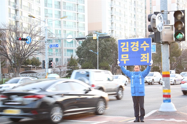  권민호 예비후보가 거리에서 '김경수 무죄' 손팻말을 들고 서 있다.