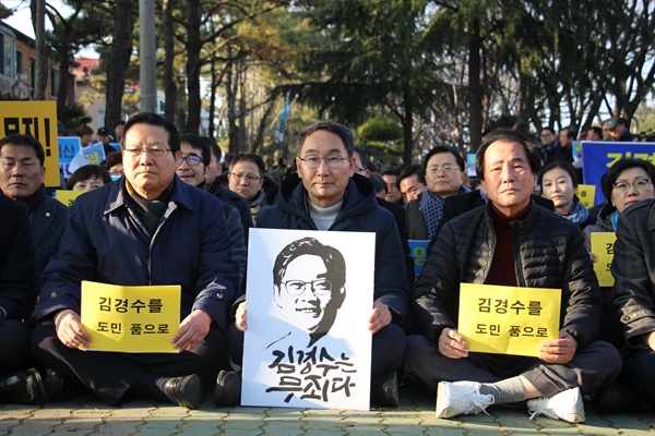 권민호 예비후보가 2월 2일 오후 창원지방법원 앞에서 열린 집회에 참석해 '김경수 무죄' 팻말을 들고 앉아 있다.