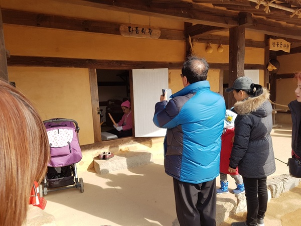 '2019 설맞이 해미읍성 민속행사'가 열리고 있는 가운데, 해미읍성을 찾은 한 관광객이 다듬이질 모습을 카메라에 담고 있다. 
