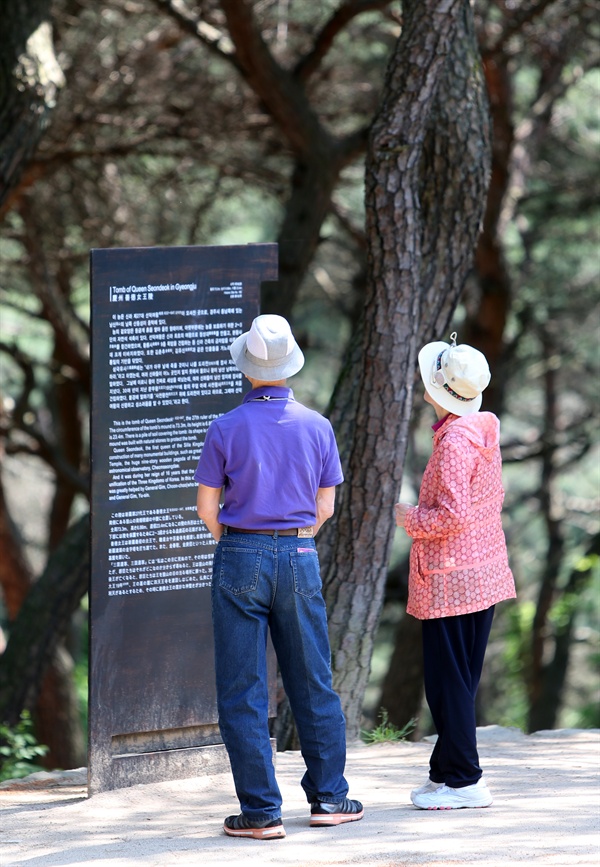 여행객들이 선덕여왕릉 입구에 세워진 안내문을 읽고 있다.
