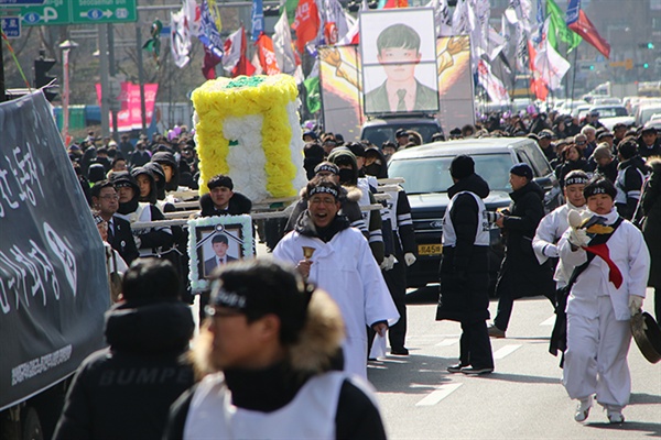  상여를 앞세우고 행진하고 있다. 