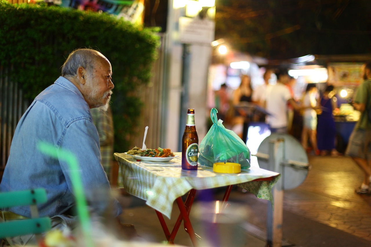 수많은 젊은 여행자들이 오가는 시장 노점에 앉은 노인. 표정이 더없이 편안해 보인다.