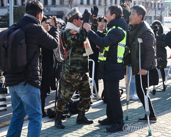 13일 오후 서울 여의도 국회 앞에서 열린 5.18 망언 비호 자유한국당 해체 촉구 기자회견에 한 군복을 입은 시민이 상경한 5.18 단체 참가자와 시민들에게 다가와 욕설을 퍼붓자, 경찰이 이를 만류하고 있다.