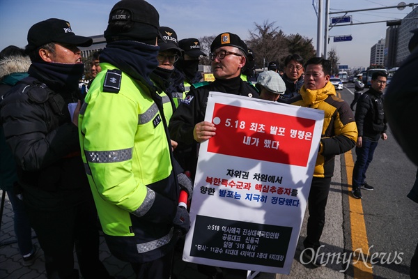 자유한국당 김진태, 김순례, 이종명 세 의원의 '5.18 망언'의 징계 결과가 발표된 14일 오전 국회 정문 앞에서 노동당, 민중당, 시민단체 등이 기자회견을 열고 '망언 3인방’을 규탄하며 자유한국당 해체를 주장하자 군복을 입은 한 보수성향의 남성이 5.18 비하 발언을 하며 기자회견을 방해하고 있다