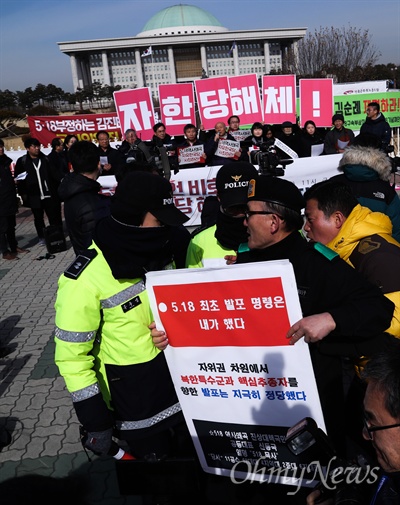 자유한국당 김진태, 김순례, 이종명 세 의원의 '5.18 망언'의 징계 결과가 발표된 14일 오전 국회 정문 앞에서 노동당, 민중당, 시민단체 등이 기자회견을 열고 '망언 3인방’을 규탄하며 자유한국당 해체를 주장하자 군복을 입은 한 보수성향의 남성이 5.18 비하 발언을 하며 기자회견을 방해하고 있다