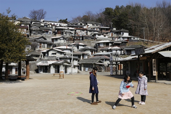 옛 추억의 놀이. 부모와 함께 순천 드라마촬영장을 찾은 어린이들이 달동네를 배경으로 옛 놀이를 즐기고 있다.