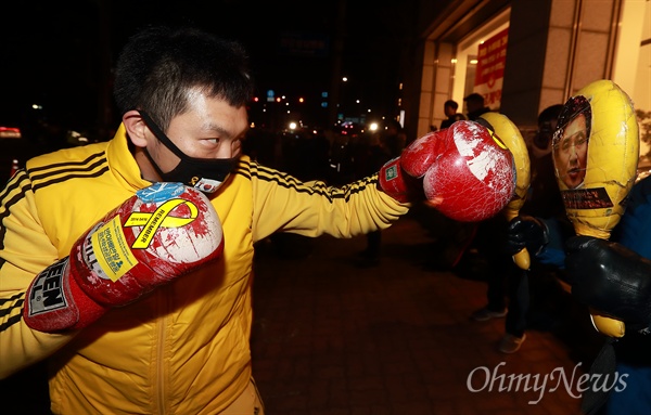  한 참가자가 김진태 의원과 극우논객 지만원씨 사진에 펀치를 날리고 있다.