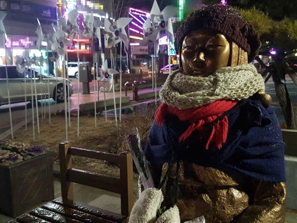 3.1 운동 100주년을 앞두고 진눈깨비가 내리는 15일 늦은 밤 '홍성 평화의 소녀상' 뒤로 태극기 바람개비가 돌아가고 있다.