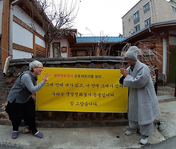 고백교회 담장 앞에서 이강실(좌측) 목사와 도법스님이 재미있는 모습을 보여줬다.