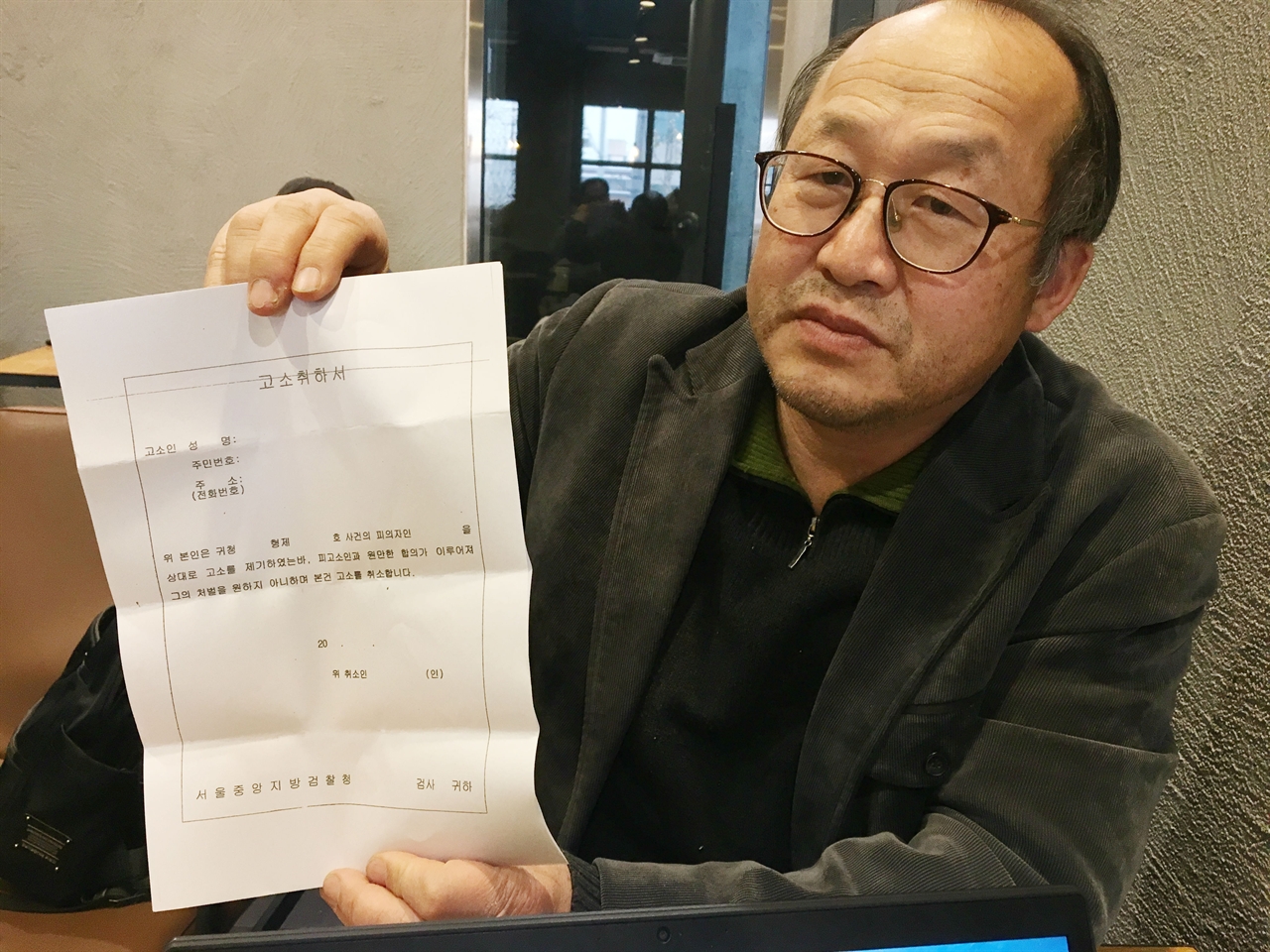 18일, 서울 마포구 합정동에서 만난 KAL 858기 가족지원단의 총괄팀장 신성국 신부가 테러범 김현희씨 고소 취하서를 보여주고 있다.