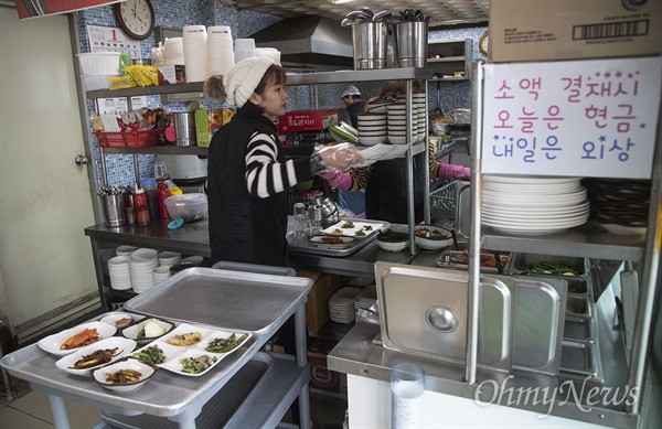 31일 전라남도 곡성군 기차마을시장 식당에서 종업원이 주문 받은 음식을 서빙하고 있다. 기차마을시장에서 뼈해장국 식당을 운영 중인 선종채(63)씨는 "경제가 갈수록 형편없어지고 있다"며 "곡성군에 주류도매업체가 3군데 있는데, 많이 힘들어한다"고 말했다.