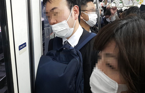 지하철 안에서 마스크를 쓰고 있는 일본 시민들. 날씨가 따뜻해지면서 점점 늘어나고 있다.