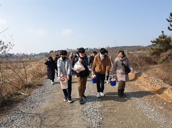  겨울철새 먹이나누기에 참가한 참가자들이 독수리에게 먹이를 들고 이동하고 있다.