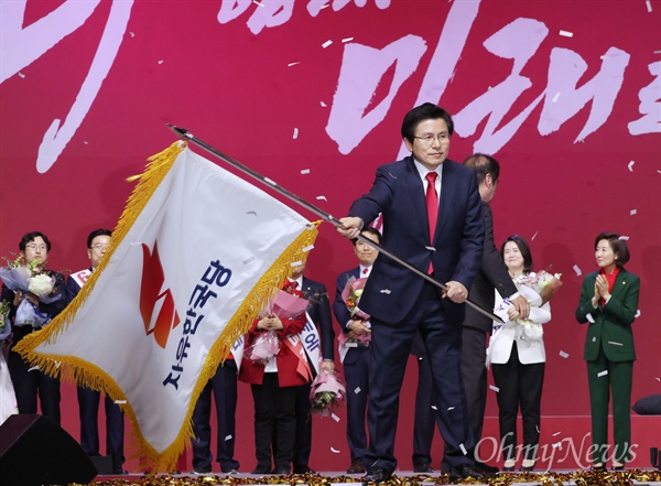 27일 경기도 고양 킨텍스에서 열린 자유한국당 제3차 전당대회에서 당대표로 선출된 황교안 후보가 당기를 받아 흔들고 있다. 