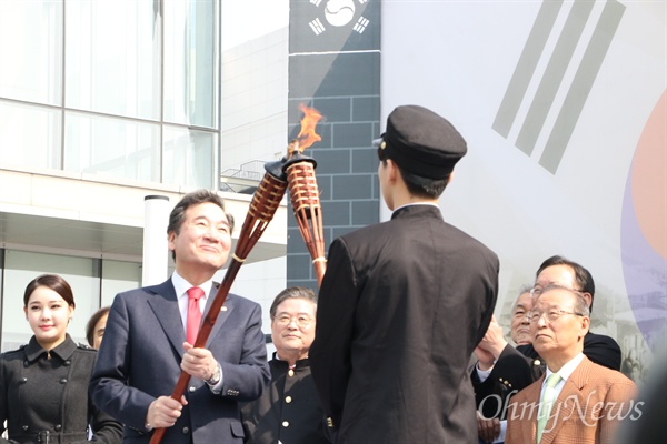  이낙연 국무총리가 28일 대구콘서트하우스 앞 광장에서 열린 2.28민주운동 학생재연 행사에 앞서 경북고등학교 학생에게 횃불을 붙여주고 있다.