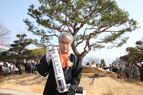 박종훈 경남도교육감이 1일 경남도교육청 앞마당에 심은 소나무 밑에 타임캡술을 묻고 있다.