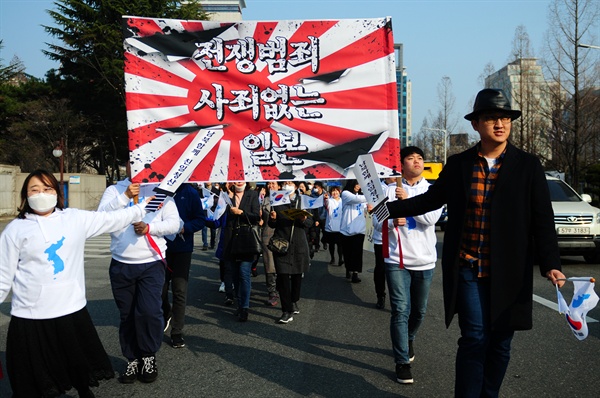 참가자들이 전쟁범죄 사죄 없는 일본을 규탄하는 내용의 퍼포먼스를 하며 행진을 하고 있다.