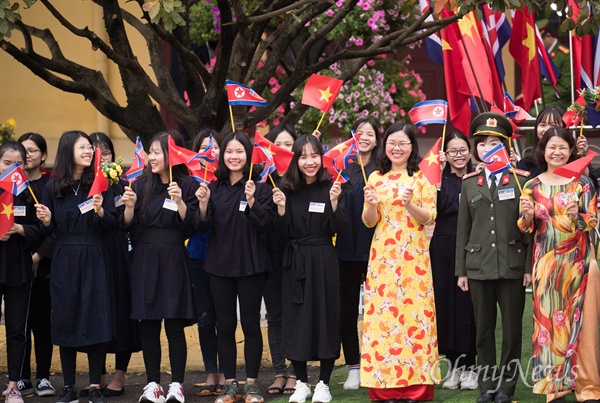 2일 베트남 국경 동당역에서 베트남 공식일정을 마친 김정은 북한 국무위원장을 환송하기 위해 전통의상을 입은 주민과 학생들이 국기를 흔들며 웃고 있다.
