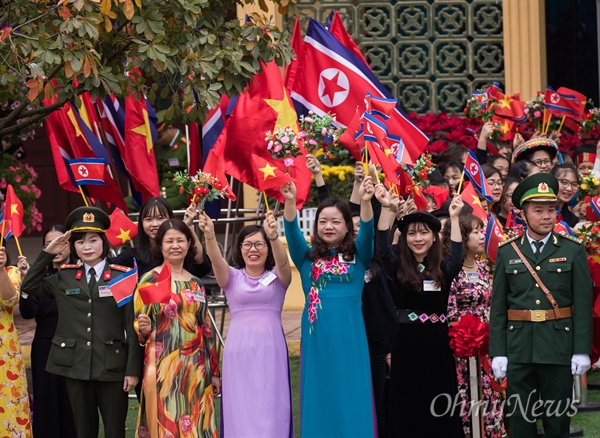 2일 베트남 국경 동당역에서 베트남 공식일정을 마친 김정은 북한 국무위원장을 환송하기 위해 전통의상을 입은 주민들이 국기를 흔들며 웃고 있다. 