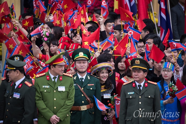 동당역에서 베트남 공식일정을 마친 김정은 북한 국무위원장이 전용열차로 떠나기 앞서 경찰이 안전통제선을 만들고 그 뒤로 주민들이 북한과 베트남 국기를 흔들고 있다. 