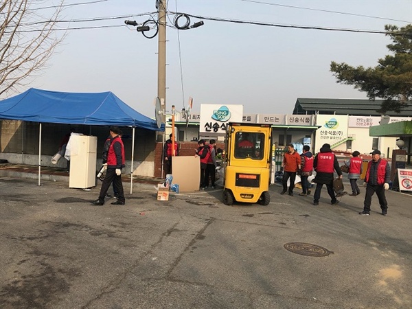  신송식품 노동자들이 천막농성장을 철거하고 청소를 하고 있다. 