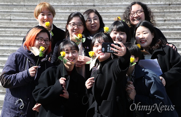 세계여성의날 노란 장미 선물에 기뻐하는 여성들 노동당과 청소년페미니즘모임, 청년정치공동체 회원들이 8일 오전 서울 종로구 세종문화회관 앞에서 3.8 세계여성의 날을 맞아 한국여성의전화 활동가들이 선물한 노란 장미를 받고 기념촬영을 하고 있다.