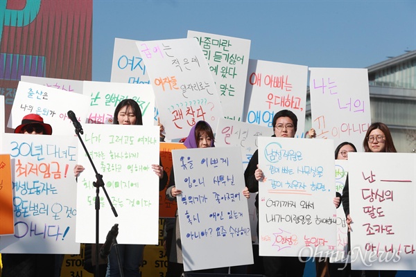 2019년 3.8세계여성의 날을 맞아 서울 광화문광장에서 '성별임금격차 해소를 위한 제 3회 3시 STOP 조기퇴근시위'가 열렸다. 참가자들이 성차별 사례가 적힌 피켓을 들고 있다.
