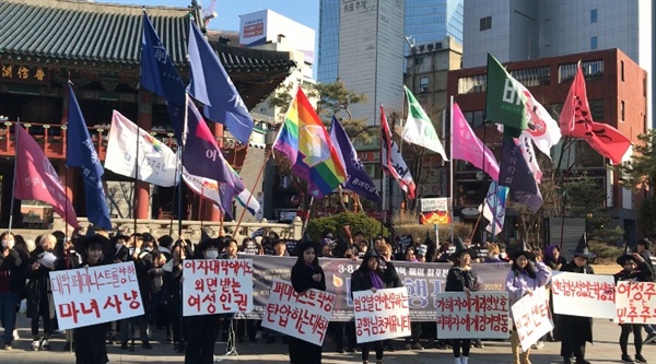 참가자들이 대학 내 성차별을 적은 피켓을 들고 있다.